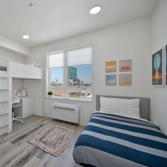 a bedroom with a bunk bed and a desk and a window