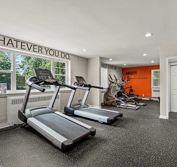 a workout room with red walls and exercise equipment