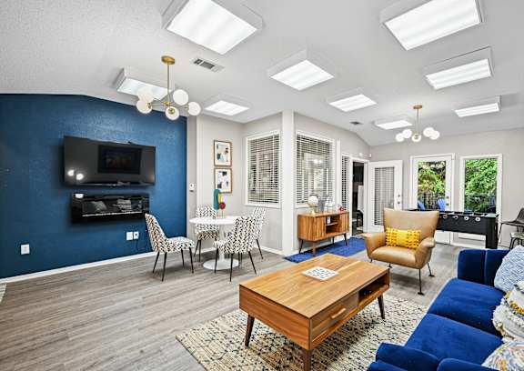 A living room with a blue accent wall and a television.