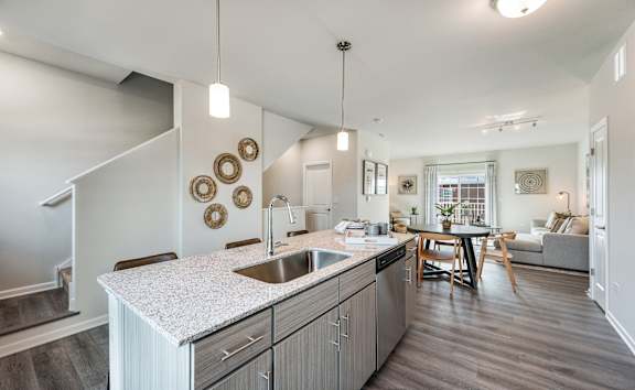 A modern kitchen with a white countertop and wooden floors.