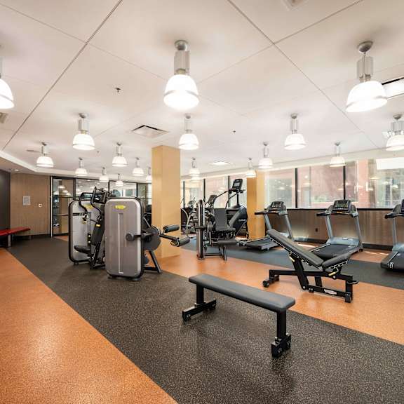 a gym with weights and exercise equipment in a room with windows