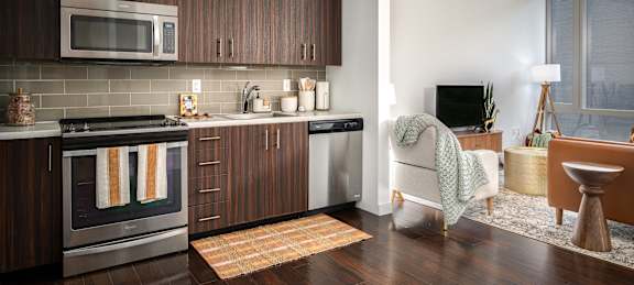 A modern kitchen with dark wood cabinets and a stainless steel oven.