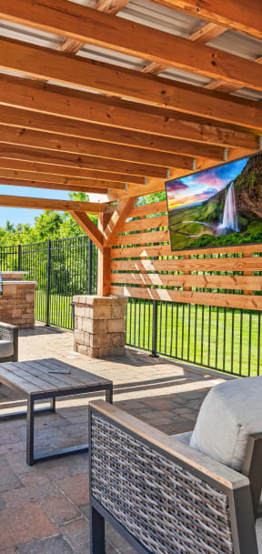 a covered patio with furniture and a grill
