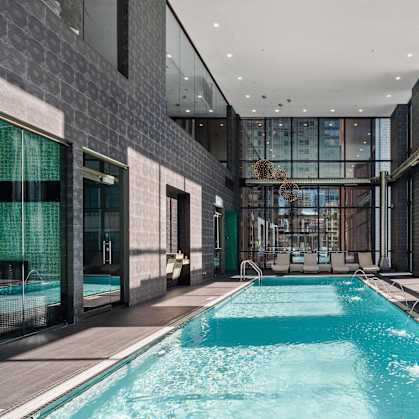 A long rectangular pool with a metal railing on the side.