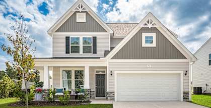 a white house with a garage door and a lawn