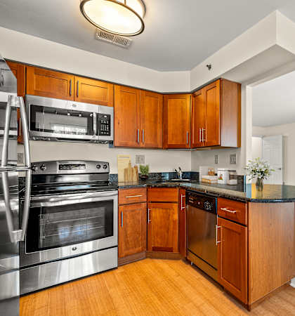 A modern kitchen with wooden cabinets and stainless steel appliances.
