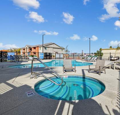 A pool with a slide and sun loungers.