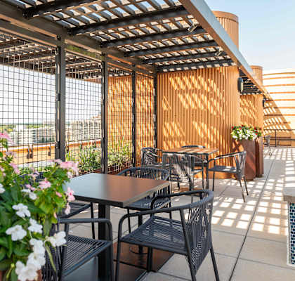 an outdoor patio with tables and chairs and a pergola