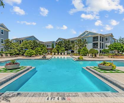 A large swimming pool surrounded by a brick border with a sign that says 4ft 4in.