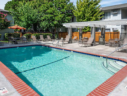 a swimming pool with chairs and a resort style pool