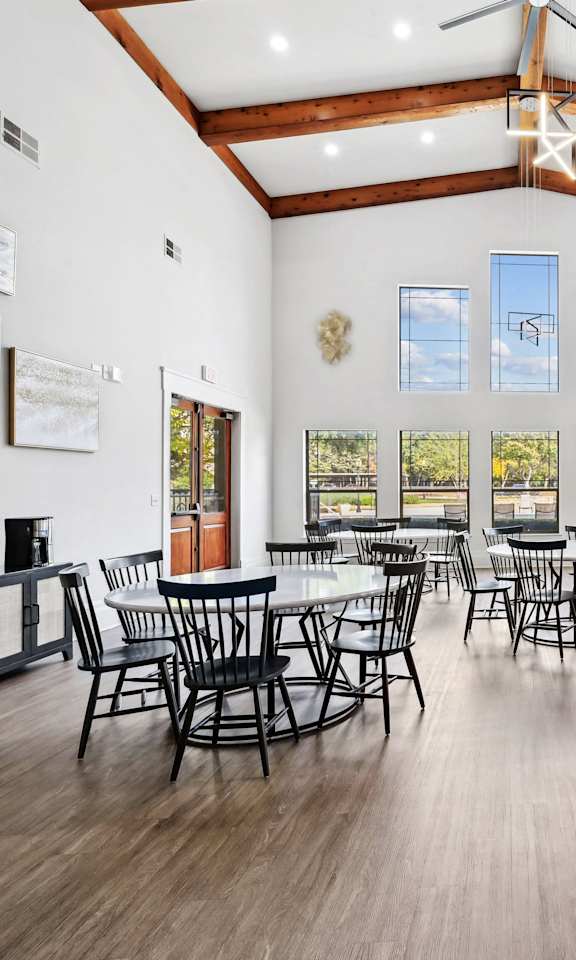 A large room with wooden floors and tables and chairs.