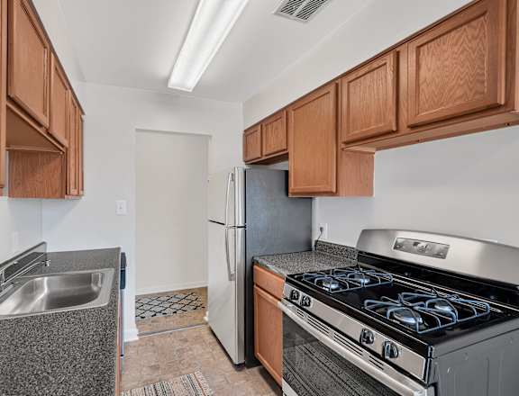 a kitchen with wood cabinets and stainless steel appliances