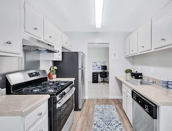 a kitchen with white cabinetry and a black stove top oven