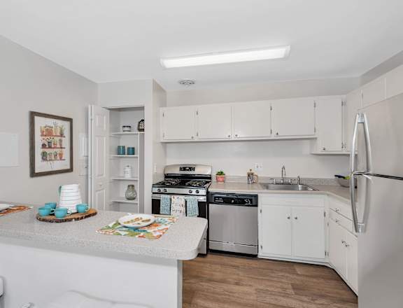 a kitchen with white cabinetry and stainless steel appliances