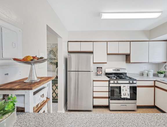 a kitchen with white cabinets and stainless steel appliances