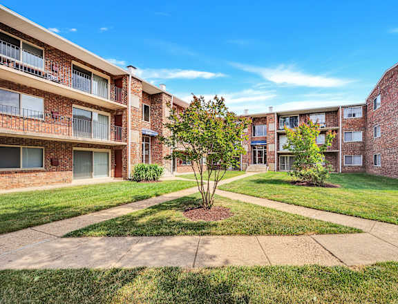 a courtyard with grass and trees at the whispering winds apartments in pearland, tx