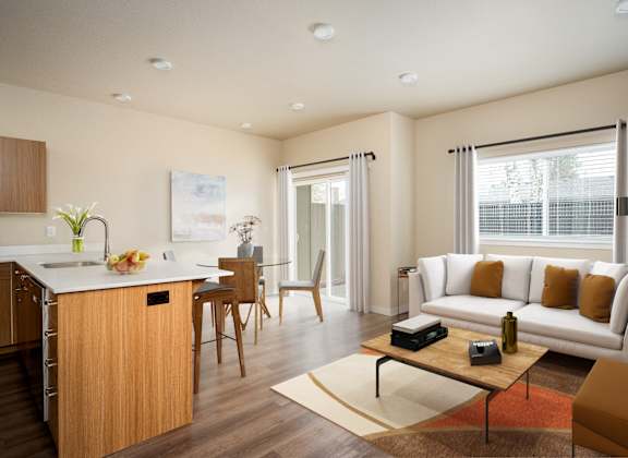 a living room and kitchen with a couch and a table