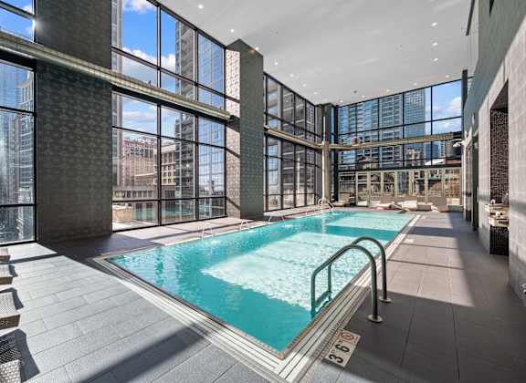 A large indoor swimming pool with a glass wall.