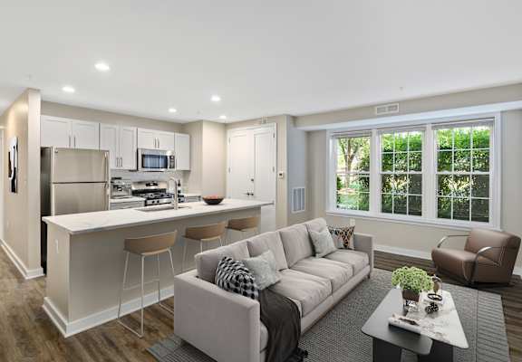 A modern living room with a kitchen area in the background.