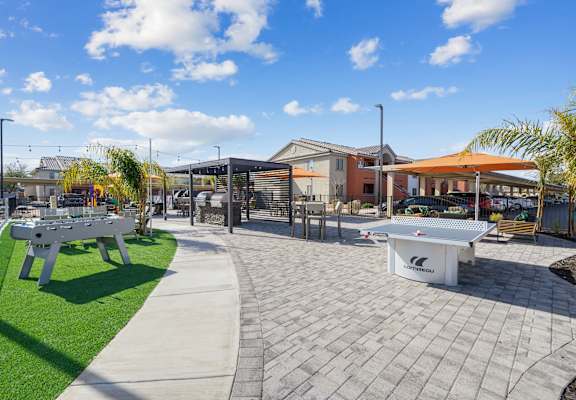 A white table tennis table is in the middle of a paved area.
