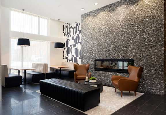 a living room with a fireplace and a black leather couch