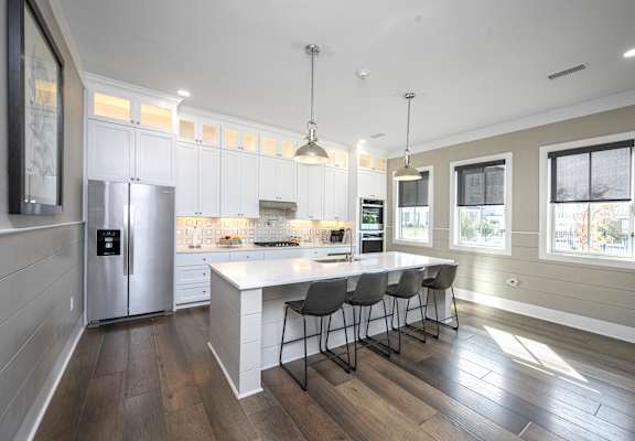 A modern kitchen with a large island and bar stools.