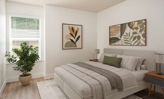 A bedroom with a bed, a potted plant, and two framed artworks on the wall.