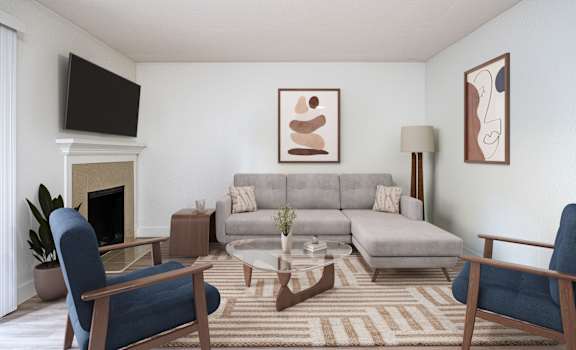 A living room with a grey couch, a blue chair, and a fireplace.