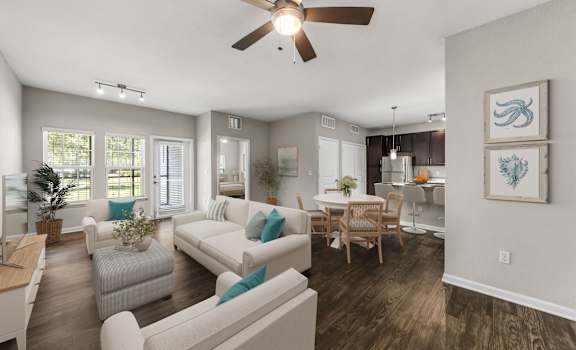 A living room with a white couch and a ceiling fan.