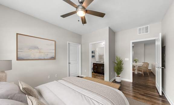 A bedroom with a large bed and a ceiling fan.