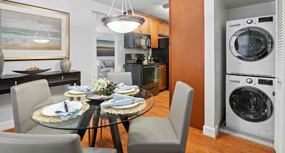 A modern kitchen with a dining table set for two.