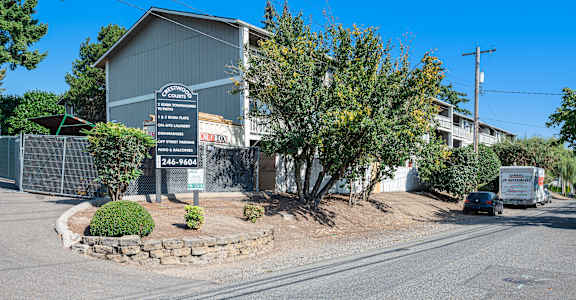 A sign in front of a building reads "Crestview Apartments" with a phone number below it.