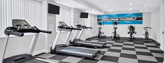 a gym with treadmills and weights on a checkered floor