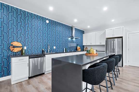 A modern kitchen with a black countertop and white cabinets.