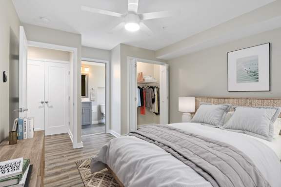 A bedroom with a large bed and a ceiling fan.