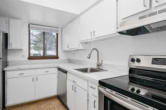 a kitchen with white cabinets and a black stove top oven
