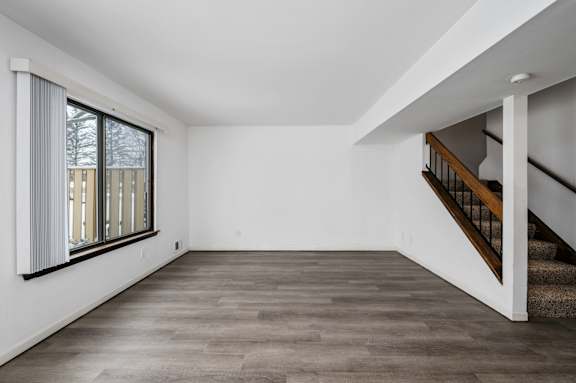 a bedroom with hardwood floors and white walls