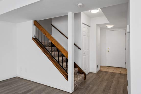 a bedroom with a medium sized bed and a staircase to the second floor