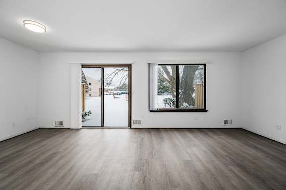 a bedroom with hardwood floors and white walls