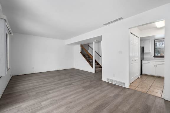 a bedroom with hardwood floors and white walls