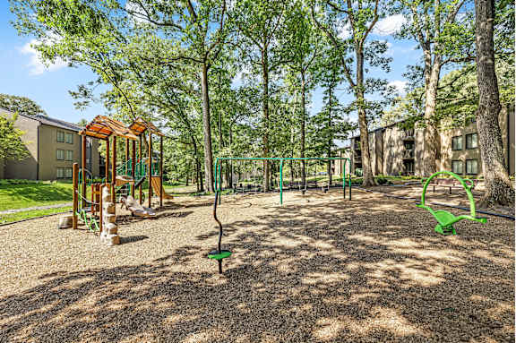 A playground with a swing set and a green slide.