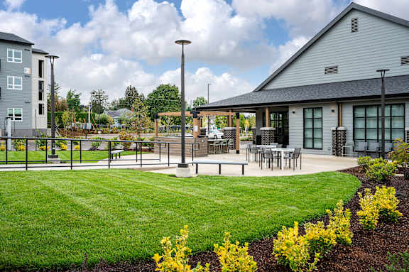 a patio with tables and chairs in front of a building