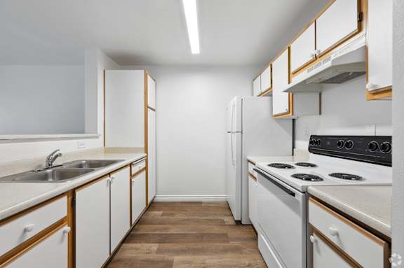 a kitchen with white appliances and wooden cabinets