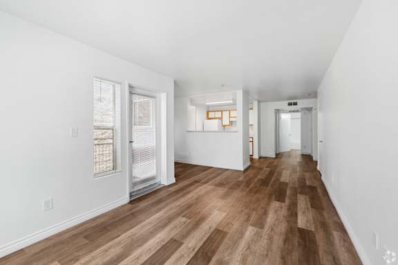 a living room with a hard wood floor and white walls