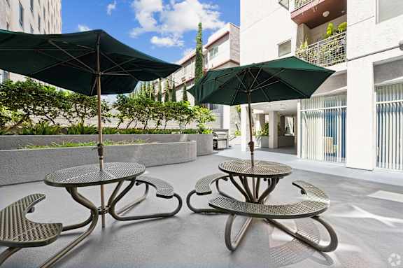 a patio with tables and chairs and umbrellas