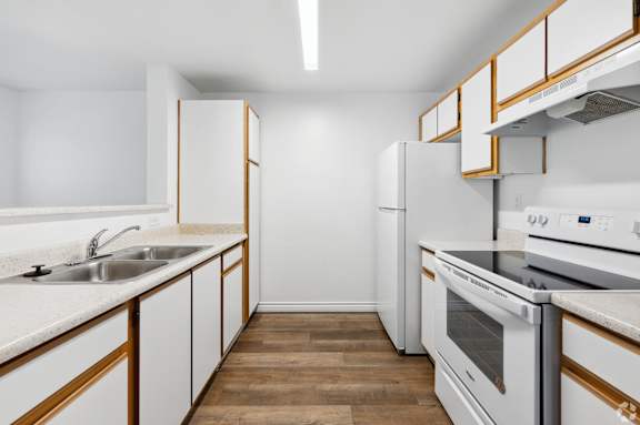 a kitchen with white appliances and wooden cabinets