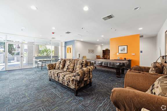 a large living room with couches and a pool table