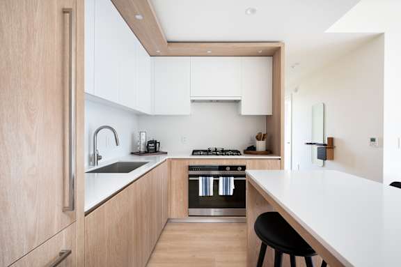 A modern kitchen with wooden cabinets and stainless steel appliances.