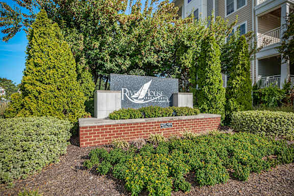  A sign for a place called River House is in front of a building.