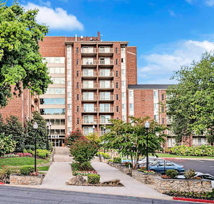 A large brick building with a tree in front of it.